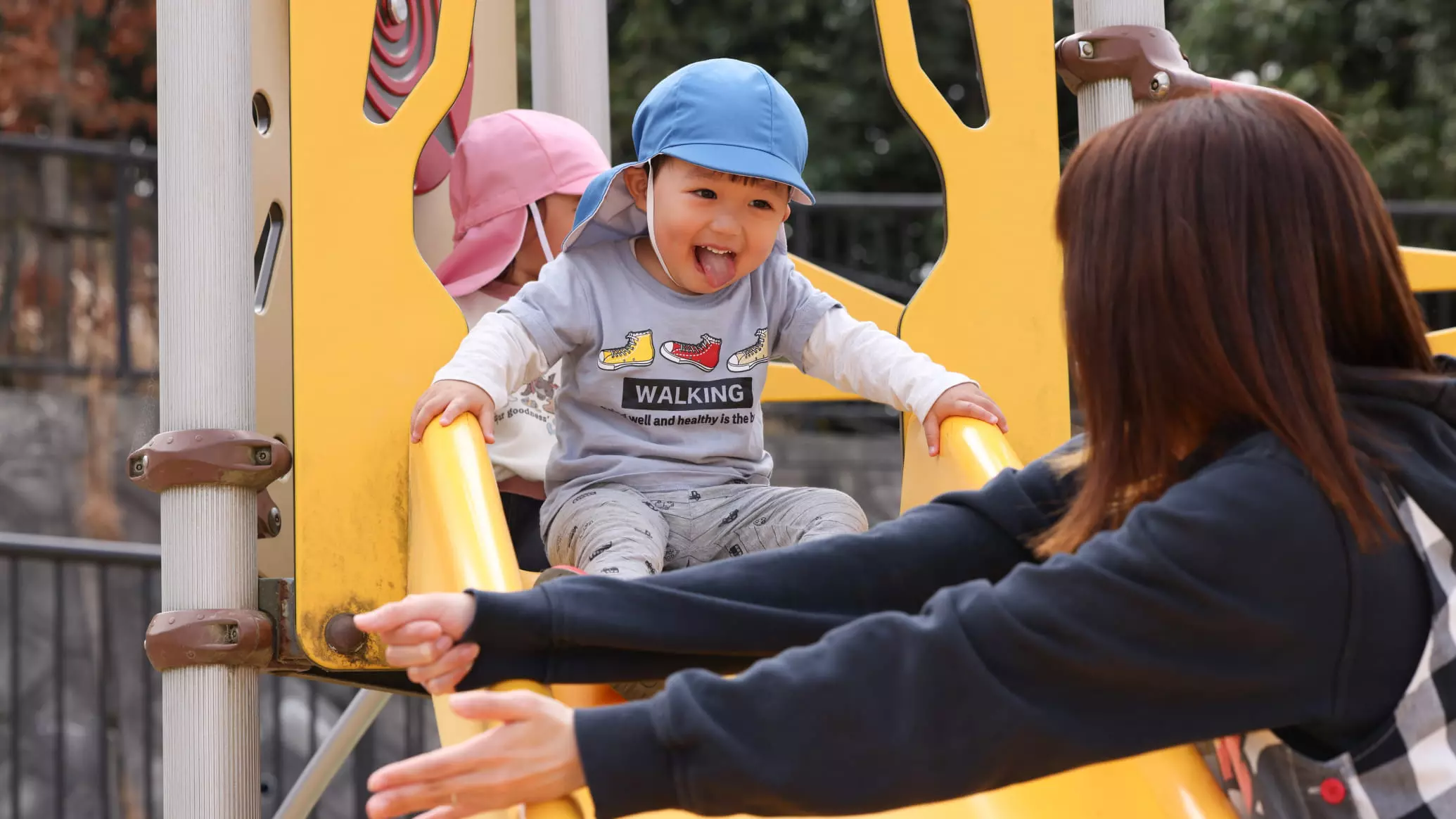 園児たちが滑り台で遊ぶ様子